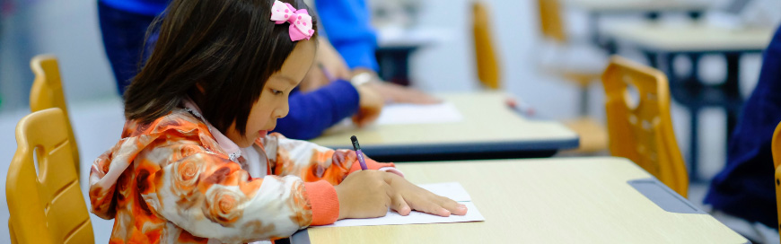 Little girl working at school desk